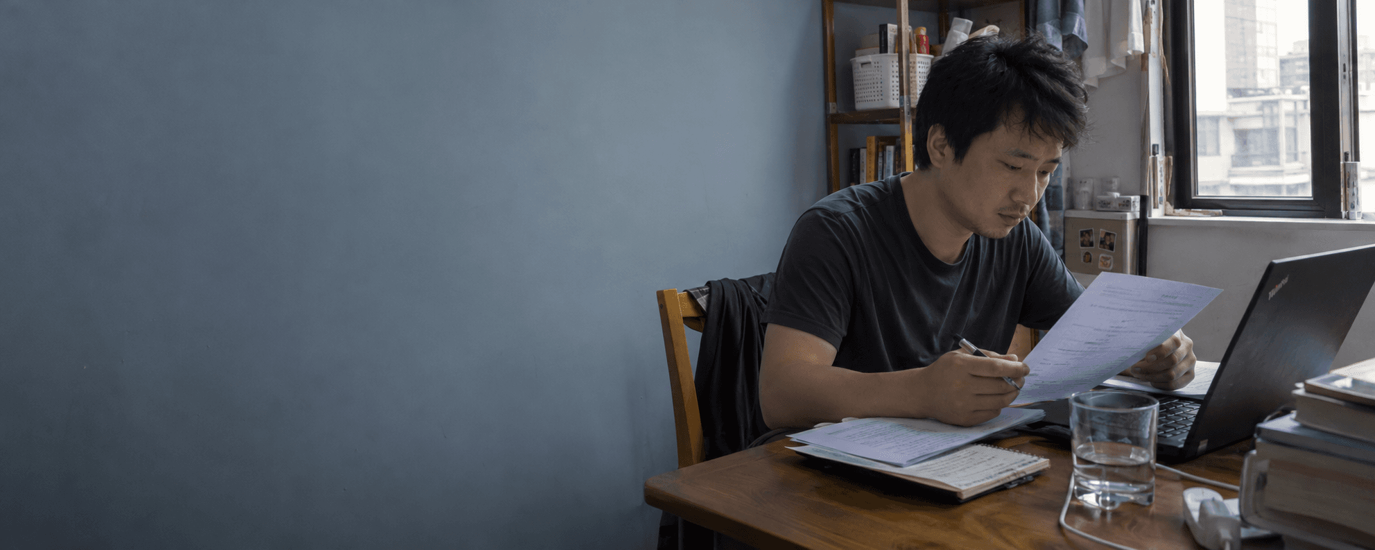 AI 生成求职场景:一位年轻人在桌前整理简历